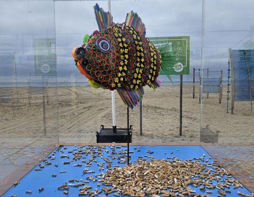 Vis gemaakt van plastic omringd door sigarettenpeuken