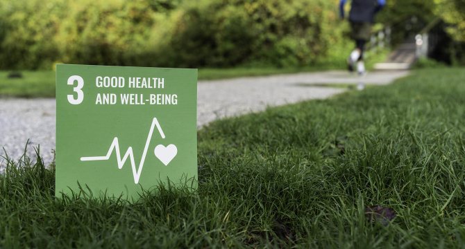 een bord met het icoon van SDG 3, gezondheid en welzijn